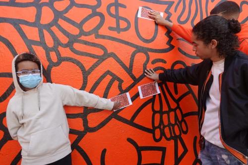 Members matching their puzzle piece to Keith Haring's Crack is Wack Mural